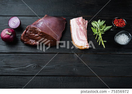 Beef liver with bacon and onion on black wooden background with copy space 75856972