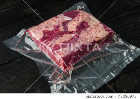 Beef brisket vacuum packed, on black wooden table background , with copyspace and space for text Beef brisket vacuum packed, on black wooden table background , with copyspace and space for text 75856973