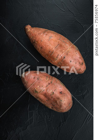 Sweet potato or batat on black background, top view Sweet potato or batat on black background, top view 75856974
