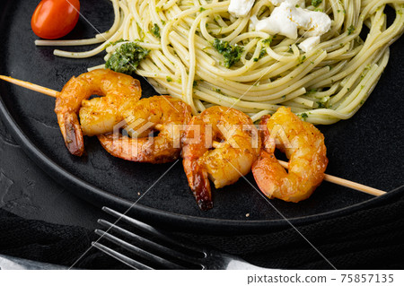 Seafood spaghetti pesto ready to eat, on plate, on black background Seafood spaghetti pesto ready to eat, on plate, on black background 75857135