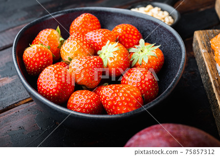 Ripe strawberry on dark wooden background 75857312