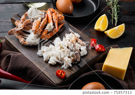 Spanish or Thai omelette ingredient, fresh red chilli, brown and white crabmeat, lemon, Cheddar cheese, eggs, on dark wooden background Spanish or Thai omelette ingredient, fresh red chilli, brown and white crabmeat, lemon, Cheddar cheese, eggs, on dark wooden background 75857313