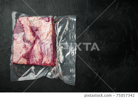 Cryovac packed meat Beef brisket in vacuum, on black stone background, top view flat lay , with copyspace and space for text Cryovac packed meat Beef brisket in vacuum, on black stone background, top view flat lay , with copyspace and space for text 75857342