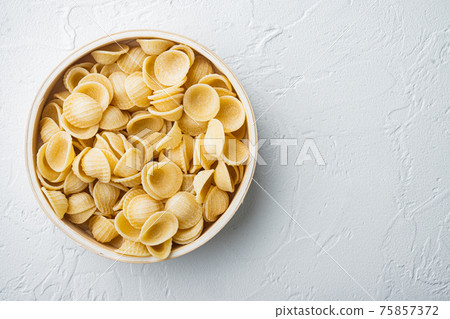 Dried pasta shells, on white background, flat lay with copy space for text 75857372