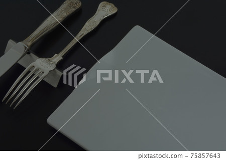 Silver British cutlery. Antique knife fork & long plate (black back soft focus) Silver British cutlery. Antique knife fork & long plate (black back soft focus) 75857643