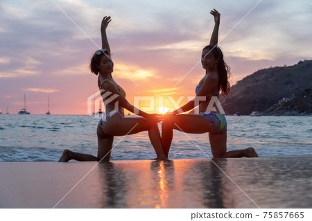 .scenery sunset behind two ladies on the beach. .scenery sunset behind two ladies on the beach. 75857665