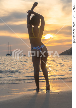 lady acting in scenery sunset on the beach. lady acting in scenery sunset on the beach. 75857666