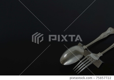 Silver British cutlery. Antique spoon fork (black back soft focus) Silver British cutlery. Antique spoon fork (black back soft focus) 75857722