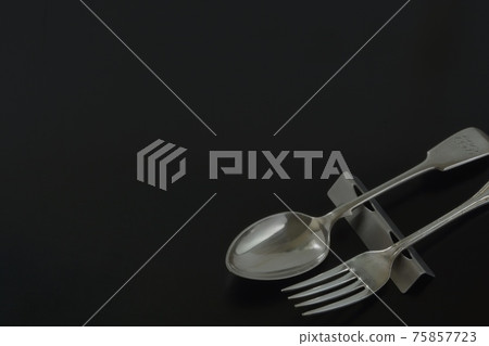 Silver British cutlery. Antique spoon fork (black back soft focus) Silver British cutlery. Antique spoon fork (black back soft focus) 75857723