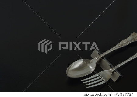 Silver British cutlery. Antique spoon fork (black back soft focus) Silver British cutlery. Antique spoon fork (black back soft focus) 75857724
