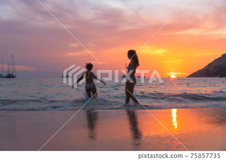 .Two women playing on the beach in the beautiful sky. .Two women playing on the beach in the beautiful sky. 75857735