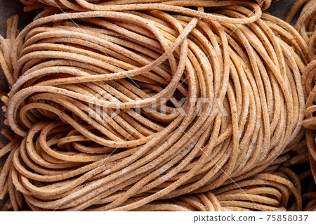 Closeup on strops of dry buckwheat noodle nests texture 75858037