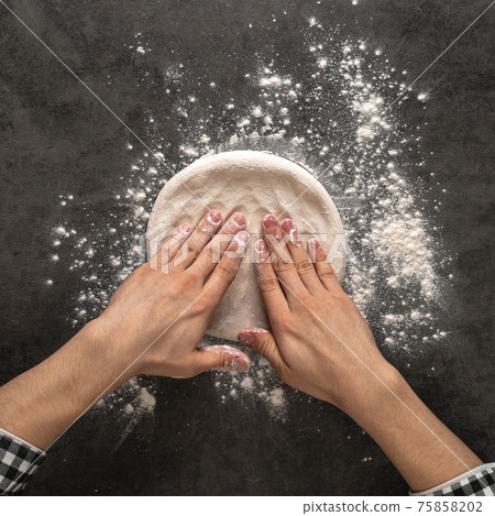 Hands making a pizza dough with flour Hands making a pizza dough with flour 75858202