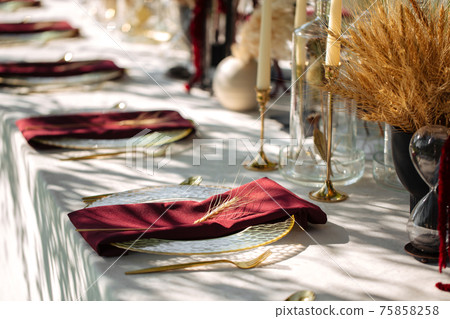Outdoors nature banquet table set with candles 75858258