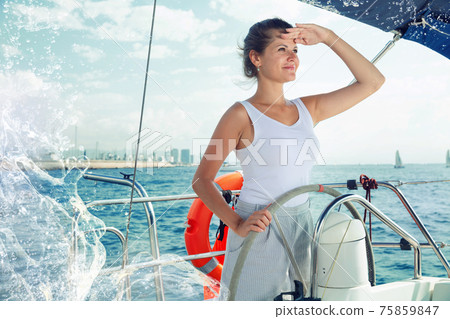 Woman standing at yacht wheel 75859847