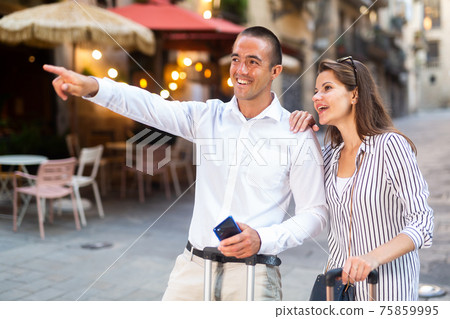 Smiling man and woman visiting city attractions on vacation Smiling man and woman visiting city attractions on vacation 75859995