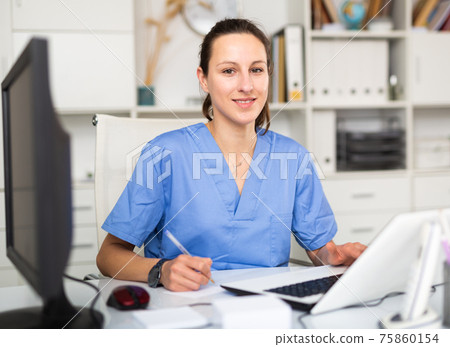 Portrait of female doctor who is working with laptop and documents Portrait of female doctor who is working with laptop and documents 75860154