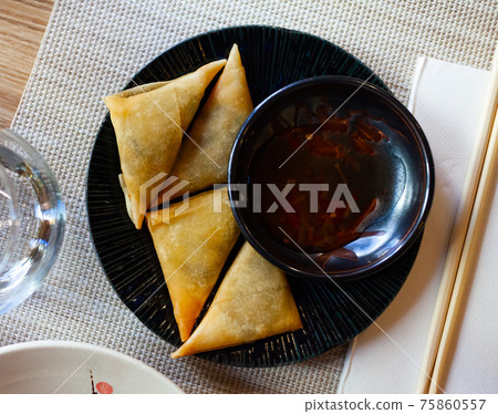 Potato curry samosas served with sause at plate Potato curry samosas served with sause at plate 75860557