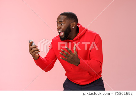 Desparate angry pissed african-american irritated man yelling smartphone look angry phone display gesturing dismay anger, furious lose last level hard game, standing bothered outraged 75861692