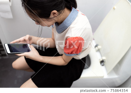 Asian schoolgirl using cell phone chat send messages sit on toilet bowl during study hours,lazy lady girl skipping class to play games in school bathroom,unwilling or lack of enthusiasm for education Asian schoolgirl using cell phone chat send messages sit on toilet bowl during study hours,lazy lady girl skipping class to play games in school bathroom,unwilling or lack of enthusiasm for education 75864354