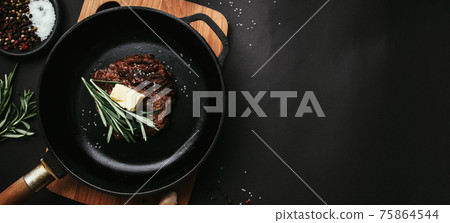 Cooked ribeye steak, cast-iron pan, pepper, rosemary, salt, garlic, butter Cooked ribeye steak, cast-iron pan, pepper, rosemary, salt, garlic, butter 75864544