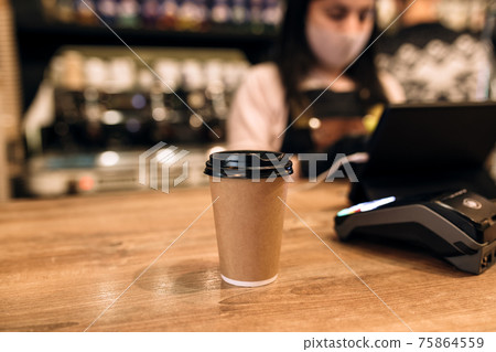 Buying a cup of coffee in a cafe, barista, NFC terminal. Blurred background 75864559