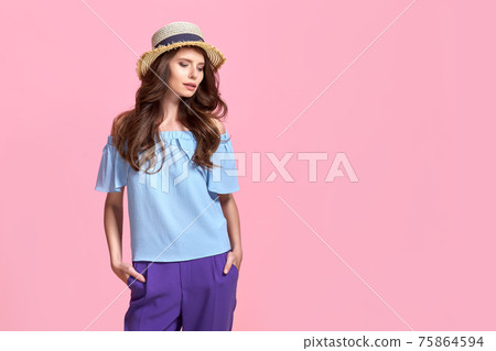 Young girl in colorful clothes wearing straw hat, isolated over pink background Young girl in colorful clothes wearing straw hat, isolated over pink background 75864594