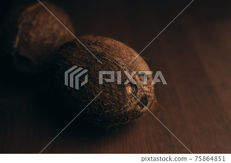 Raw coconut on the wooden oak table. Blurred background Raw coconut on the wooden oak table. Blurred background 75864851