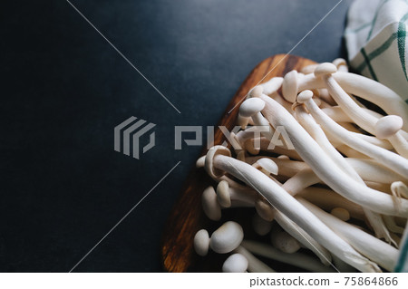 Cooking white mushrooms on the dark gray background 75864866