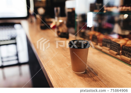 Paper coffee cup on bar counter in cafe. Blurred background Paper coffee cup on bar counter in cafe. Blurred background 75864906