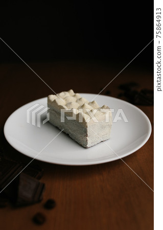 White cheese cake on plate on brown wooden table, chocolate. Blurred background White cheese cake on plate on brown wooden table, chocolate. Blurred background 75864913
