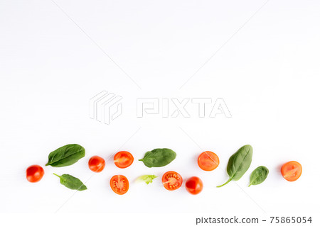 Red cherry tomatoes, green spinach leaves on white background. Healthy eating 75865054