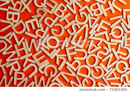 wooden cut alphabet letters on orange background 75865369