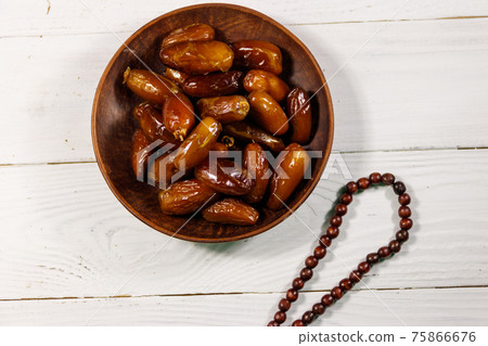 Dates fruit and rosary on white wooden table. Top view 75866676