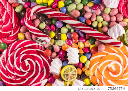 Background of colorful chocolate candies, lollipops, candy cane and marshmallows 75866754