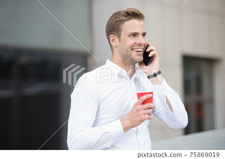 Man drink coffee speak phone urban background. Drink Man drink coffee speak phone urban background. Drink 75869019