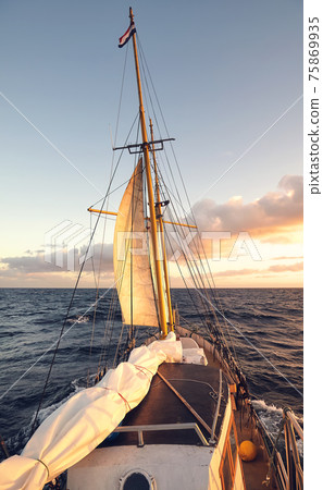 Sailing old schooner at sunset, travel and adventure concept. Sailing old schooner at sunset, travel and adventure concept. 75869935