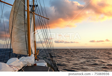 Sailing old schooner at sunset, travel and adventure concept. Sailing old schooner at sunset, travel and adventure concept. 75869936