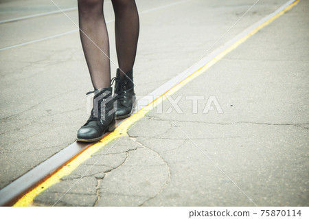 Girl walking on the tracks of the tram 75870114