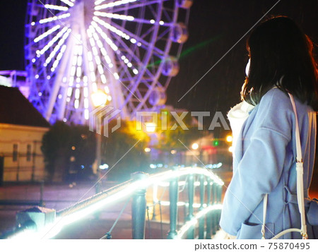 Girl watching the ferris wheel at night Girl watching the ferris wheel at night 75870495