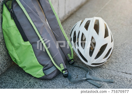 Close up of backpack and white hemet on granite surface 75870977