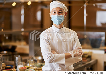 Proud chef posing in his workplace near the kitchenware 75871101