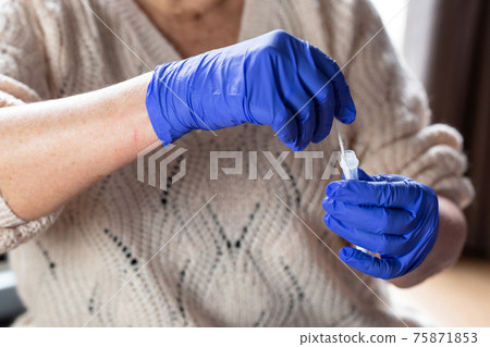 Senior woman studying and taking the self test for Covid-19, home test kit for coronavirus 75871853