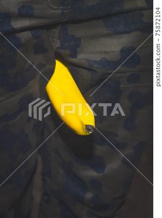 Banana between human legs close-up. Concept of funny contests, humor 75872104