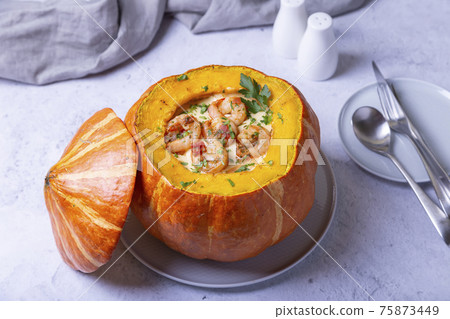Pumpkin stuffed with shrimps and cheese, whole baked. Traditional Brazilian dish. Close-up. 75873449
