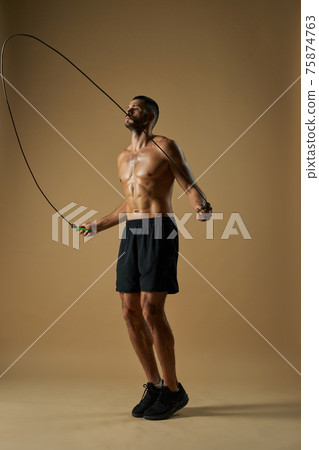 Strong adorable sportsman with powerful body doing sport exercises in the indoors Strong adorable sportsman with powerful body doing sport exercises in the indoors 75874763