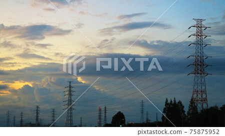 Scenery of dusk sky with dark clouds, power lines and towers Scenery of dusk sky with dark clouds, power lines and towers 75875952