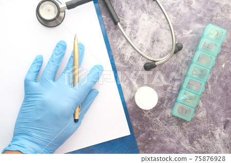doctor hand in latex gloves writing prescription on desk, close up. doctor hand in latex gloves writing prescription on desk, close up. 75876928
