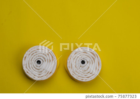 New replaceable filters for Industrial respirator with yellow background. Personal respiratory protection equipment. Production safety. Flat Lay. New replaceable filters for Industrial respirator with yellow background. Personal respiratory protection equipment. Production safety. Flat Lay. 75877323