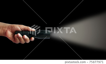 Black flashlight in human hands on a black background, including a white beam. 75877971
